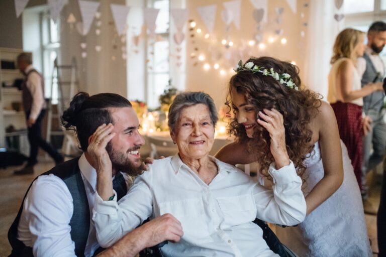 Un jeune couple avec grand-mère sur un mariage, posant pour une photo